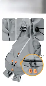 Detail view of grey backpack featuring orange zippers and thick padded top handle
