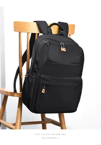 Dettaglio dello zaino in nylon nero impermeabile con vivaci tiretti arancioni