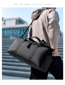 Man carrying a black waterproof travel bag with dual straps on modern stairs
