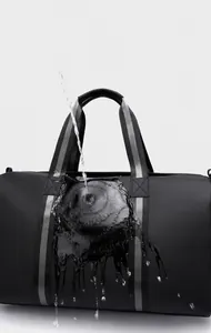 Detailed shot showing high-density waterproof fabric of the black travel bag with water splashes