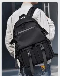 Side view of black nylon backpack with tactical straps and buckle pockets on model