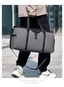 Outdoor shot of a large gray and black travel bag with dry-wet separation and shoulder strap