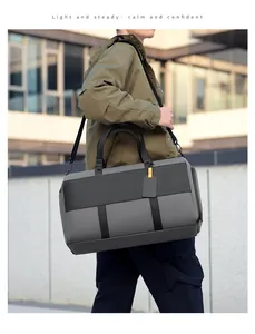 Outdoor shot of a gray travel bag featuring reinforced handles and adjustable shoulder strap