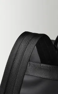 Detailed close-up of wide padded shoulder straps on a black heavy-duty travel backpack