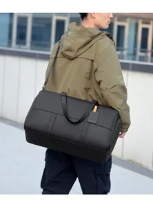 Macro detail of a large black fitness bag showing reinforced handles and matte synthetic fabric