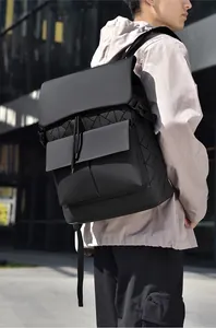 Detail of geometric triangle pattern on black backpack with top flap and drawstring