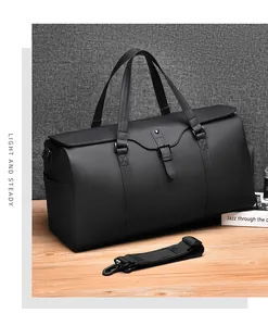 Detail view of black waterproof travel bag with leather texture and detachable strap
