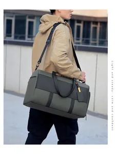 Detail view of large olive green travel duffel bag with shoulder strap and dual handles
