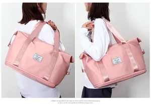 Vista lateral detallada del bolso de viaje rosa con correas anchas y compartimento con cremallera