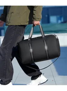 Close-up of black travel duffle bag with striped handles and adjustable shoulder strap