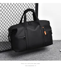 Detail of black travel duffle bag with orange luggage tag on industrial background