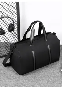 Detail of black waterproof travel bag with reinforced handles and detachable shoulder strap