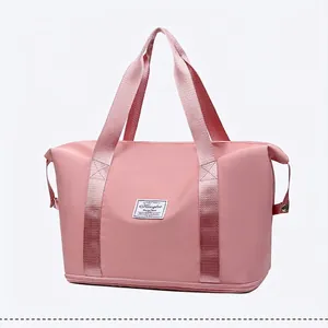 Dettaglio borsa da viaggio rosa in nylon impermeabile con fondo espandibile e manici robusti