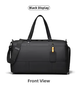 Detail view of black waterproof travel bag with double handles and adjustable shoulder strap