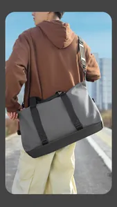 Dettaglio della borsa da viaggio grigia con tracolla rinforzata e tessuto impermeabile