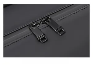 Close-up of durable metal double zippers on black matte waterproof travel bag