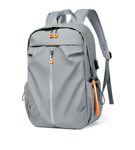 Side view of gray travel backpack with orange zipper accents and external USB charging port