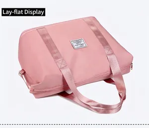 Dettaglio borsa da viaggio rosa in nylon con doppi manici e chiusura con cerniera in metallo