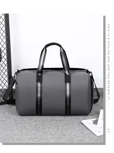 Detail of grey waterproof travel bag with striped handles and removable shoulder strap