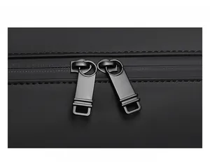 Close-up of smooth two-way metal zippers on black waterproof travel duffel bag