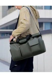 Army green waterproof travel bag shown worn as a crossbody bag in an urban setting