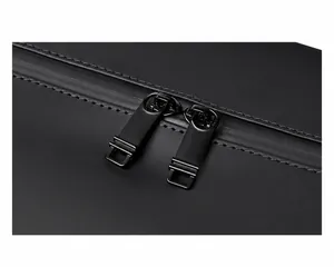 Close-up of durable dual metal zippers on a black travel bag with waterproof matte fabric