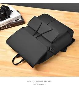 Detail of black diamond-quilted backpack on wood desk with camera and books