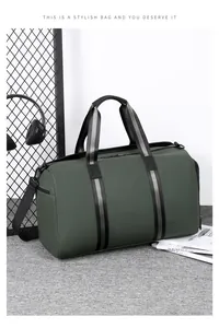 Detail view of large green waterproof travel bag with striped handles and shoulder strap