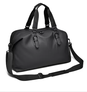 Dettaglio borsa da viaggio nera opaca impermeabile con doppi manici e tracolla imbottita