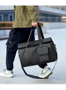 Close-up of a large black travel duffel bag with functional front pockets and sturdy strap