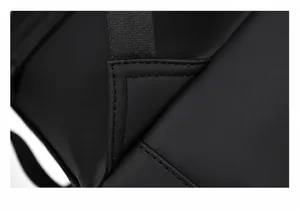 Detail of reinforced triangle stitching on black travel backpack strap for extra durability