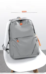 Close-up of light grey water-resistant backpack showing orange zipper details and layers