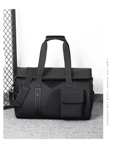 Detail of black waterproof travel bag with reinforced handles and adjustable shoulder strap