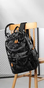 Détail du sac à dos camouflage avec fermetures éclair orange et port USB externe