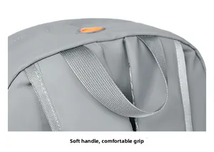 Close-up of a soft grey handle and orange cable hole on a water-resistant backpack