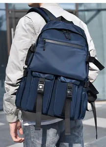 Detail of navy blue water-resistant nylon backpack with multi-pocket design and buckles