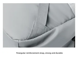Macro view of reinforced triangular strap stitching on a gray nylon business backpack