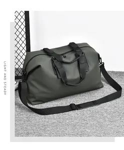 Dettaglio della borsa da viaggio oliva con cinghie nere e scritta LIGHT AND STEADY
