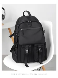 Detail view of black nylon backpack with multi-pocket design on white chair