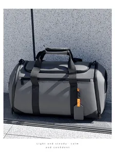Détail du sac de voyage gris foncé montrant la texture en nylon et le zip orange vif