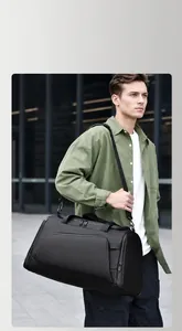 Detail of waterproof black travel bag with adjustable strap and multiple zipper pockets