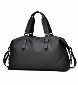 Detail of waterproof black travel duffel featuring reinforced handles and side buckle straps