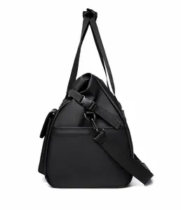 Detail view of the black travel bag showing the side pocket with snap closure and strap