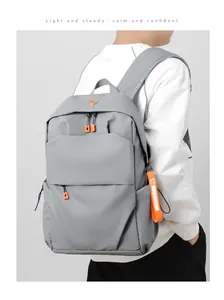 Close-up of grey backpack fabric with vibrant orange zipper and decorative strap details