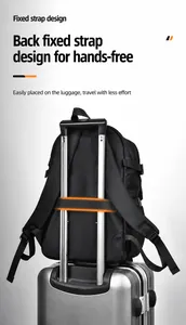 Detail of black backpack with integrated luggage strap secured on a silver suitcase handle