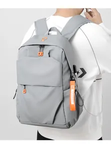Detail of grey casual backpack featuring an external USB port and orange zipper accents