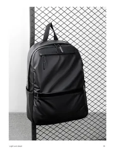 Detail view of the sleek matte waterproof fabric and multiple zippers on the black backpack