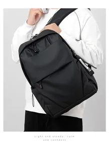 Man wearing a black waterproof backpack with hidden zipper and decorative tag