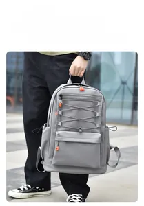 Detail of light grey multi-pocket backpack featuring orange zippers and mesh mesh pocket