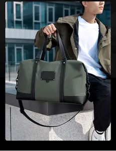 Detailed view of olive green waterproof travel bag with black handles and shoulder strap